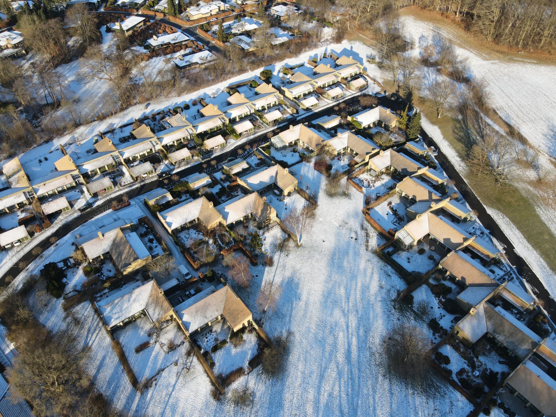 Dronefoto af dansk villakvarter med sne på tagene